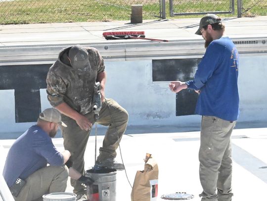 Workers dive into swimming pool repairs