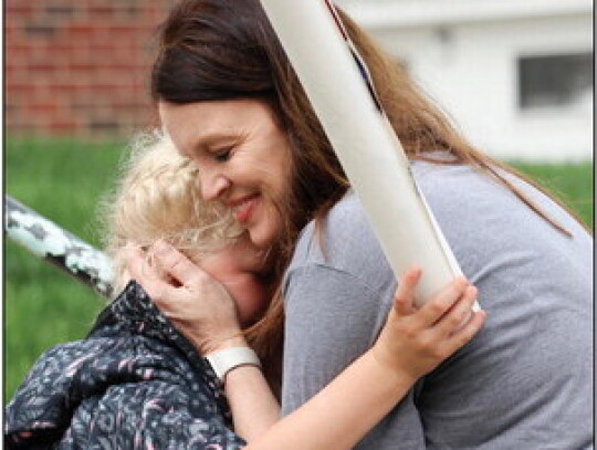 Lisa Wolfgram gives Elizabeth Kneifl a goodbye hug as they dismiss school for the summer on Friday. Sandra Cross | Laurel Advocate