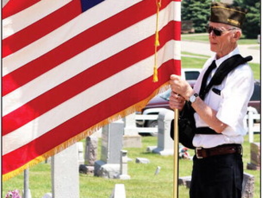 Dwayne Freeman stands with the American flag as a list of fallen comrades are read during Laurel’s Memorial Day services at the cemetery. Sandra Cross | Laurel Advocate