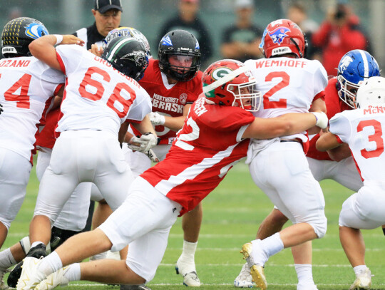 (top) Cedar Catholic’s Grant Arens snags a ball out of the air during first-half action in Saturday’s Northeast Nebraska All Star game in Norfolk. (left) Lane Heimes runs upfield to churn out some yardage during Saturday’s contest. (above) Jay Steff