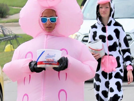 Paisley Burns (above) holds on to one of the ping-pong balls she snagged during Laurel’s Pool Party Friday night. The event kicked off the community’s annual Ag Days celebration. (left) Taelynn Settje (front) and Ava Christiansen (back) walk along the