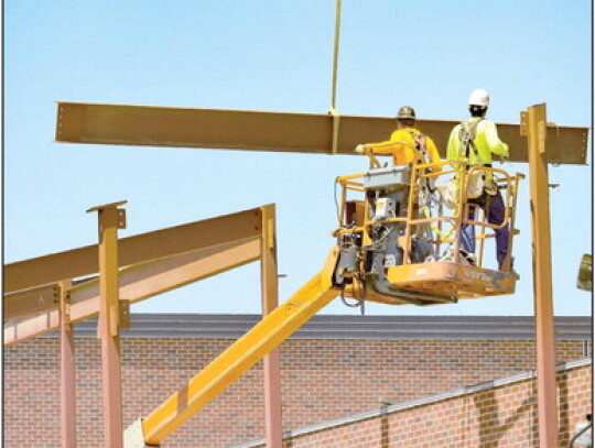 A construction crew guides the girder to the awaiting beam. Workers continue on the Phase II portion of the LCC school addition project. Sandra Cross | Laurel Advocate