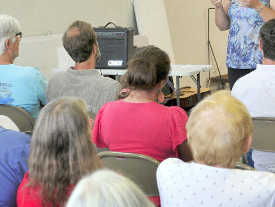 Pastor Charity Potter of the Unity Presbyterian Parish leads a church service at the Belden fire hall on Sunday morning as part of the town swimming pool’s 100th birthday celebration. Darin Epperly | Laurel Advocate