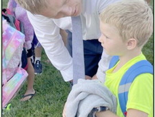 First grader Kyler Papenhausen gives a goofy greeting to his classmates on opening day of the 2023-24 school year at Randolph Elementary Thursday morning. Top right, Elementary Prinicpal Denton Beacom calms kindergartner Colton Burbach. Jackie Loberg|Rand