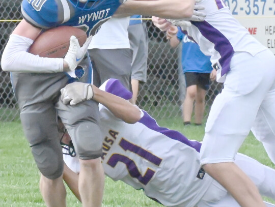 The Wynot Blue Devils took on the Wausa Vikings Friday afternoon in football. Wynot’s Kotner Koch (left) drags a few Vikings on his way to a first down. Joseph Sudbeck (above) of Wynot pulls Wausa’s Mac Carlson back from gaining the first-down yardage