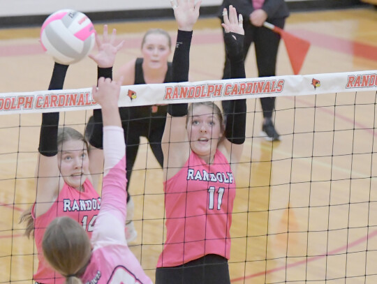 Alexis Backhaus and Katarina Greiner stretch for the block in their match against Osmond at home for Pink Out night Oct. 12. The match proved to be a battle in a grueling fourset encounter. The Lady Cardinals fell short (29-27, 20-25, 26-24, 25-22). Two d