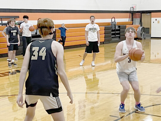 The Randolph-Osmond Hawks boys and girls basketball teams gear up for the 2023 season with productive practices this week. Sophia Gansebom and Mabel Ngebeh (above) race to the other end of the court. Luke Harder stands guard against Owen Severson (photo a