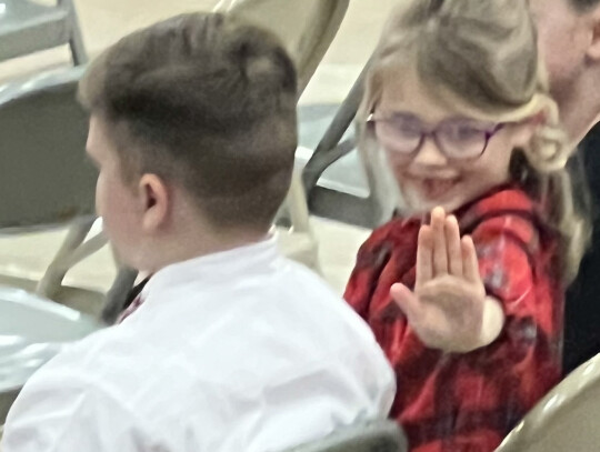 Santa turns the tables and sits on Brent Billerbeck’s lap during Randolph Rescue’s regular meeting Monday night. In the photo at right, thirdgrader Kaysen Henry gives a “Hi, Mom” wave to the crowd during Randolph Elementary’s winter concert Dec. 5