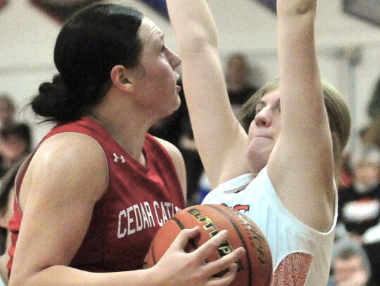 Cedar Catholic’s Addison Walter drives in for a layup as LCC’s Rena Rasmussen sets up in hopes of drawing a charging foul. Cedar earned the victory. Darin Epperly | Laurel Advocate