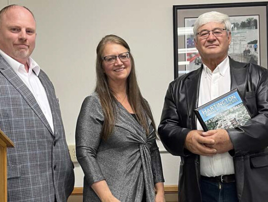 Hartington Chamber of Commerce Vice President Ray Sukovaty and President Karen Flamig present Alan Kathol with a plaque honoring the 25th anniversary of Kathol Turf.