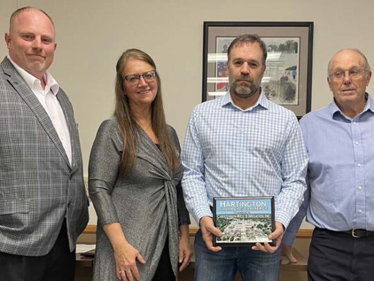 Hartington Chamber of Commerce Vice President Ray Sukovaty and President Karen Flamig present Carly Christensen and Bill Christensen with a plaque honoring the 50th anniversary of Christensen Well &amp; Irrigation.