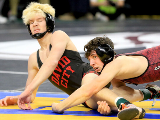 Cedar Catholic’s Brady Hochstein (above) struggles to free himself from his foe during action in the fifth-place match Saturday at the Class C-2 State wrestling tournament in Omaha. (left) Cedar Catholic’s Braeden Hochstein tried to keep David City’