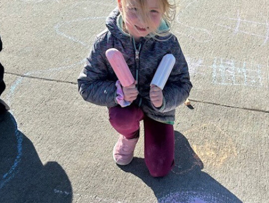 Skye Burns shows off some of the chalk art she helped create. Laurel-Concord-Coleridge Elementary students were rewarded for their positive behavior in February by going outside to create art. The students enjoyed the sun and took time to spread kindness 