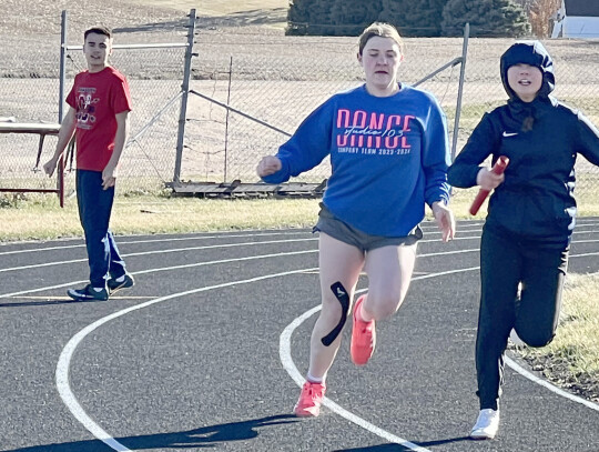 Freshman Hunter McGhee waits his turn, watching as Senior Nicole Haselhorst passes the baton to Freshman Lilly Kuchta during track practice Monday afternoon. The track season opened this week when the Cardinals traveled to Vermillion to the University of 