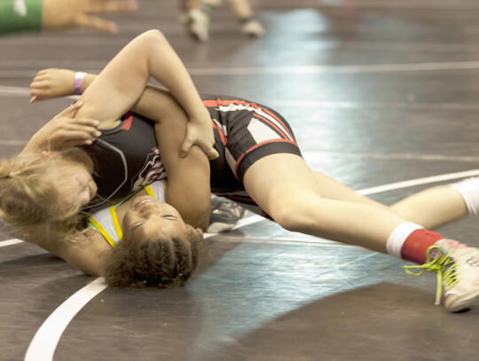 The League of Heroes just completed another successful season. Five members of the Hartington youth wrestling team wrestled for state titles recently. (above) State champion Harper Evans checks in with coaches as she works to turn her foe over during Stat