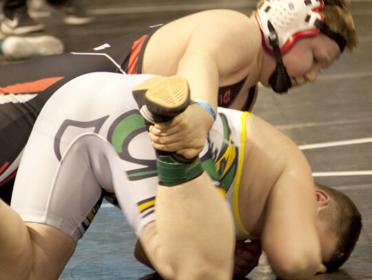 Evie Freeman (left) celebrates her State championship win by jumping into the arms of coach Justin Bartling. Ruby Freeman (middle) earns an escape against her foe during State wrestling action. (above) Riggin Fischer works from the top position in one of 