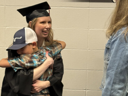 Jake Harder celebrates graduation day with tongue out and hands up following the RHS graduation ceremony Saturday afternoon. At right, Rylee Thelen receives a hug from her cousin, Cooper Backhaus. For more graduation photos, see page 8. Jackie Loberg|Rand