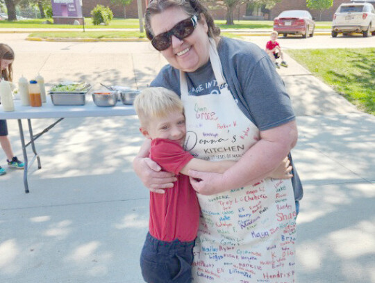 Donna Burbach hugs first-grader Wyatt Pinkelman on May 14 during a picnic for Cedar Catholic High School and Holy Trinity Elementary. Burbach is retiring soon from her role of food service manager/head cook at the Hartington grade school. Mark Mahoney | C