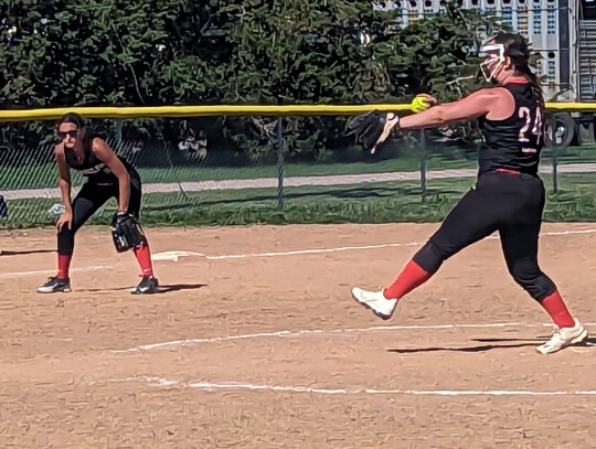 Above, Delayne Thelen gets a pitch off while Peyton Thelen readies for action at third base during the 18U tournament at Laurel over the weekend. At left, Randolph’s 8U team energize each other in the huddle between innings.